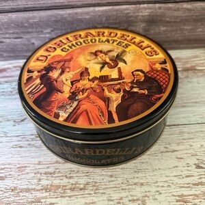 D. Ghirardelli’s Chocolate tin black with Victorian family scene and angel
